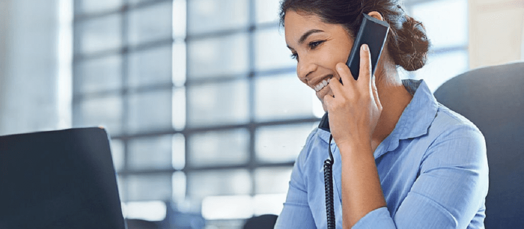 Women in blue shirt talking on the phone.